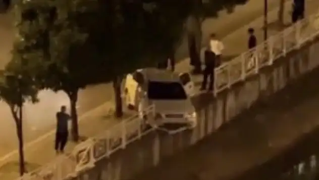 Adana'da sulama kanalı korkuluğuna çarpan araç asılı kaldı