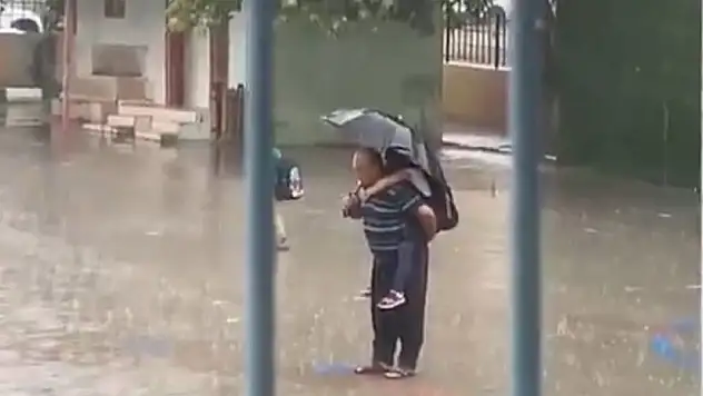 Dede ve torundan duygulandıran manzara: Torununu sırtına alarak yağmur altında İstiklal Marşı okudu