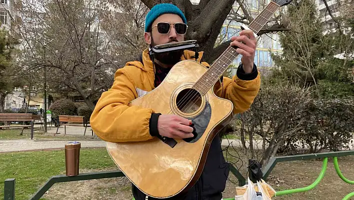 Sokak müzisyeni Srbazi hem mızıka hem gitar çalıyor!